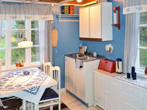 cocina con fregadero, mesa, mesa y sillas en Three-Bedroom Holiday home in Gullesfjord en Flesnes