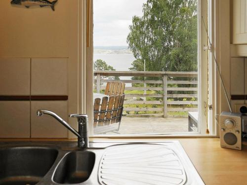 a kitchen with a sink and a view of a balcony at 4 person holiday home in H viksn s in Höviksnäs