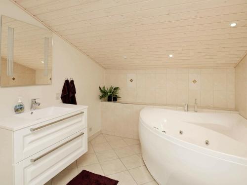 Baño blanco con bañera y lavamanos en 8 person holiday home in N rre Nebel en Lønne Hede