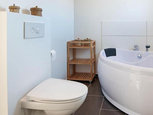 a white bathroom with a toilet and a sink at 14 person holiday home in Glesborg in Glesborg