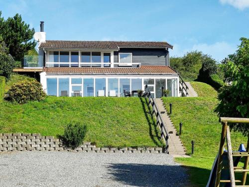 a large house on top of a grassy hill at 8 person holiday home in Ebeltoft in Ebeltoft