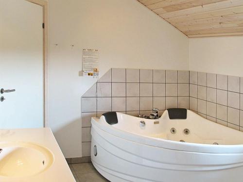 a white bath tub in a bathroom with a sink at 8 person holiday home in V ggerl se in Marielyst