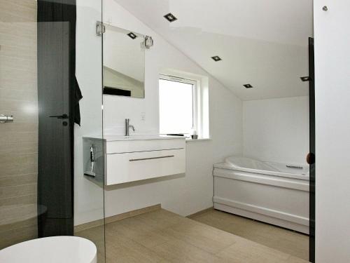 a bathroom with a toilet and a sink and a tub at 6 person holiday home in Hadsund in Øster Hurup