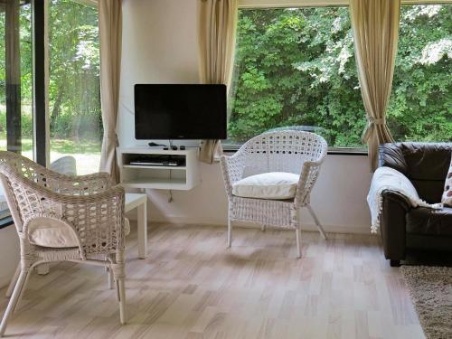 sala de estar con 2 sillas, TV y ventanas en 4 person holiday home in Hals, en Hals