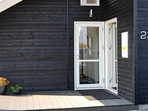 uma casa negra com uma porta branca em 10 person holiday home in Sydals em Vibøge