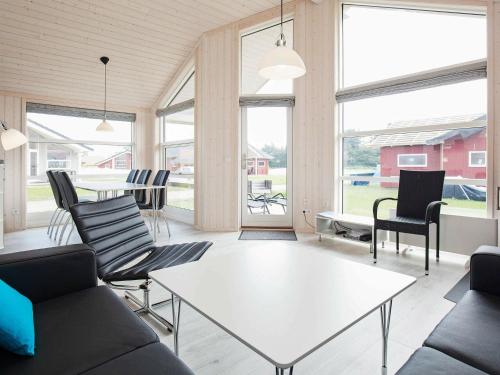 グローセンブローデにある6 person holiday home in Gro enbrodeのリビングルーム(白いテーブル、椅子付)