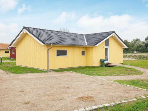 a yellow house with a black roof at 10 person holiday home in Gro enbrode in Großenbrode