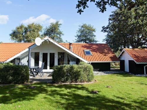 a white cottage with an orange roof on a yard at 6 person holiday home in Hemmet-By Traum in Hemmet