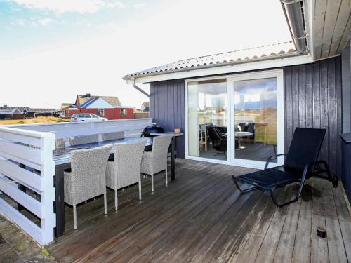 a deck with chairs and a table on a house at 6 person holiday home in Lemvig in Ferring