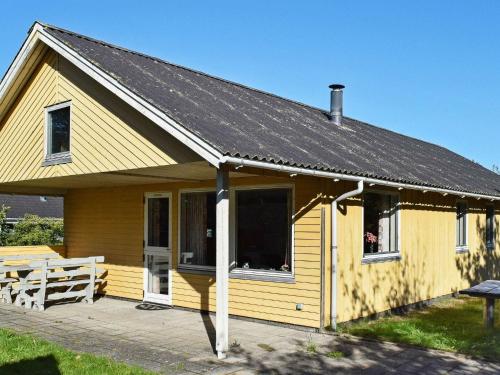 una pequeña casa amarilla con techo solar en 6 person holiday home in Ulfborg en Ulfborg