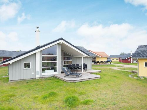a small white house with a patio in a yard at 8 person holiday home in Gro enbrode in Großenbrode
