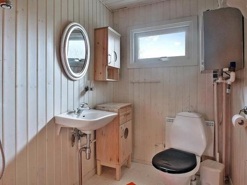 y baño con aseo, lavabo y espejo. en Holiday home Storvorde III, en Storvorde