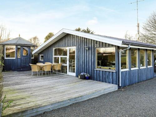 Casa azul con terraza de madera con sillas en 5 person holiday home in S by, en Saeby