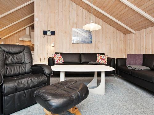 ein Wohnzimmer mit einem Sofa, einem Tisch und Stühlen in der Unterkunft 6 person holiday home in Oksb l in Oksbøl
