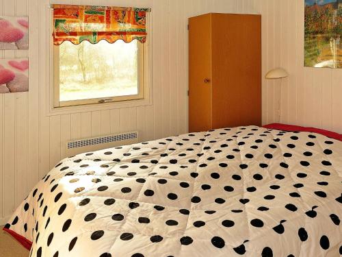 1 dormitorio con edredón blanco y negro en una cama en Three-Bedroom Holiday home in Nørre Nebel 16, en Lønne Hede