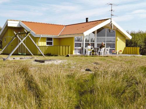 una casa amarilla con techo rojo en 10 person holiday home in Fan en Fanø