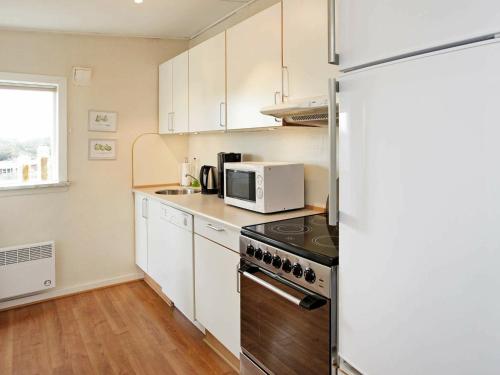 a kitchen with a refrigerator and a microwave at 4 person holiday home in Vejers Strand in Vejers Strand