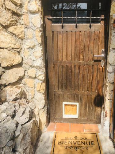 une porte en bois avec un panneau de bienvenue devant elle dans l'établissement Cabane de L Esteron, à Gilette