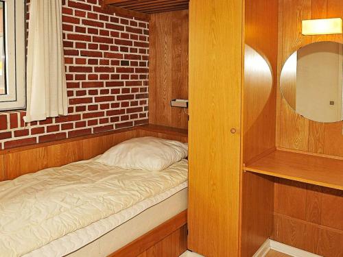 a small bed in a room with a brick wall at 6 person holiday home in Henne-By Traum in Henne Strand