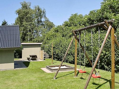 a swing set in a yard with a playground at 6 person holiday home in Hemmet in Falen