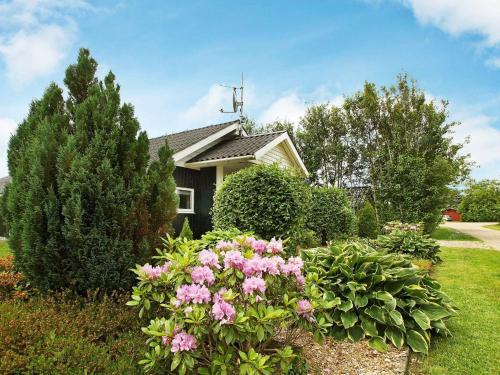 a house with pink flowers in front of a yard at 8 person holiday home in Tarm in Hemmet