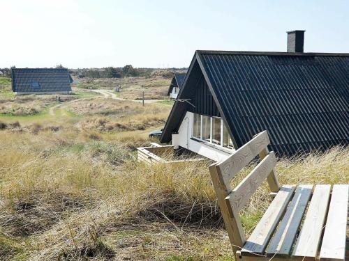 a small house with a bench in front of it at 6 person holiday home in Ringk bing in Klegod