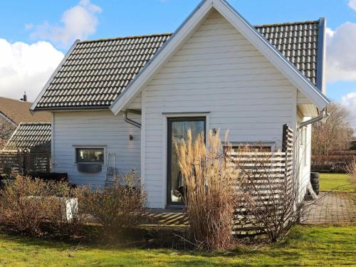 een wit huis met een raam en een aantal struiken bij 4 person holiday home in FALKENBERG in Falkenberg