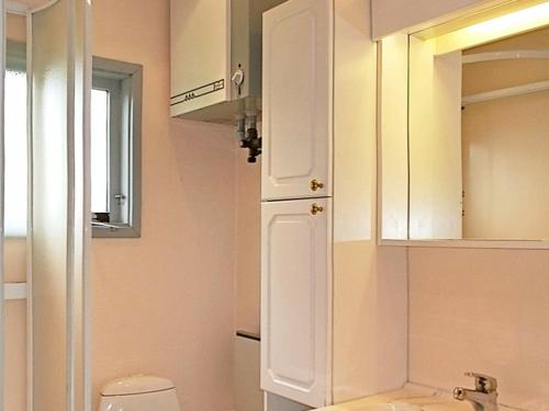 W łazience znajduje się toaleta, umywalka i lustro. w obiekcie Two-Bedroom Holiday home in Lemvig 22 w mieście Lemvig