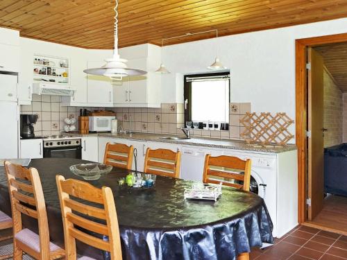 Oddeにある8 person holiday home in Hadsundのテーブル、椅子、テーブル、キッチンが備わります。