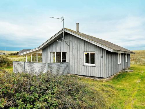 a small house in a field of grass at 8 person holiday home in Harbo re in Harboør