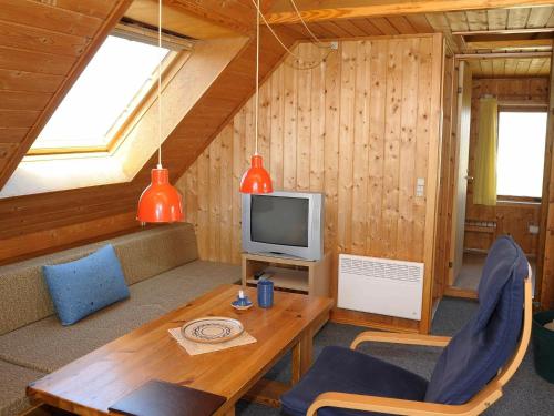 a living room with a table and a television at 6 person holiday home in Ringk bing in Klegod