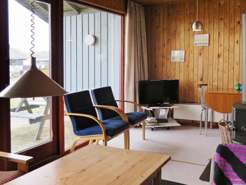 a living room with two chairs and a television at 8 person holiday home in Harbo re in Harboør