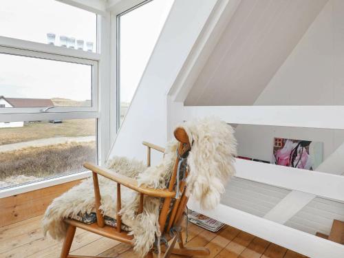 HarboørにあるThree-Bedroom Holiday home in Harboøre 24の窓付きの客室で、毛皮で覆われたロッキングチェアが備わります。