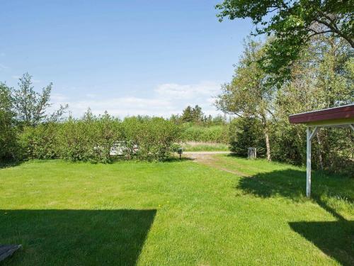 a yard with a field of grass and trees at 8 person holiday home in Hurup Thy in Sindrup