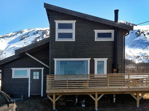 a house with a porch with a snow covered mountain at 6 person holiday home in Nord Lenangen in Sørlenangen