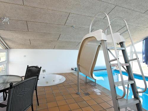 Un tobogán de agua en una habitación con piscina en Five-Bedroom Holiday home in Hjørring 2, en Lønstrup