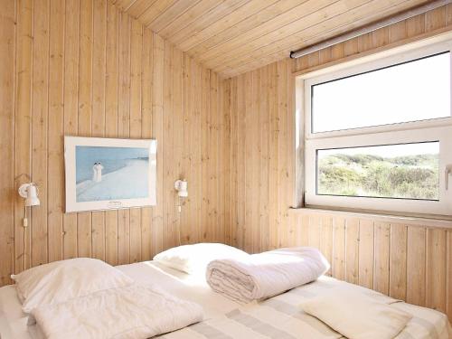 ein Schlafzimmer mit einem Bett in einer Holzwand in der Unterkunft Five-Bedroom Holiday home in Hjørring 2 in Lønstrup