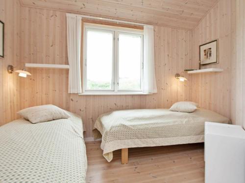 1 dormitorio con 2 camas y ventana en 8 person holiday home in Ulfborg, en Fjand Gårde