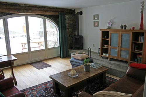 uma sala de estar com um sofá e uma mesa em B&B Le Tapis Rouge em Vielsalm