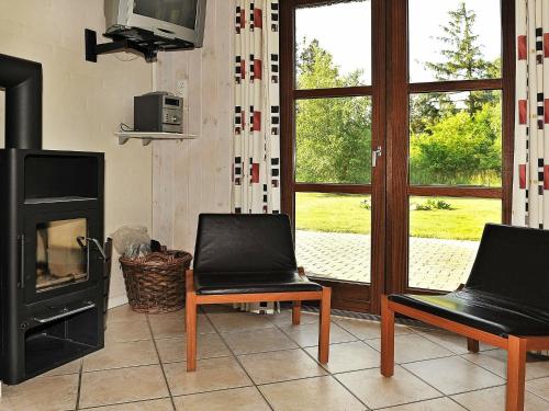 a living room with two chairs and a fireplace at 8 person holiday home in N rre Nebel in Nørre Nebel