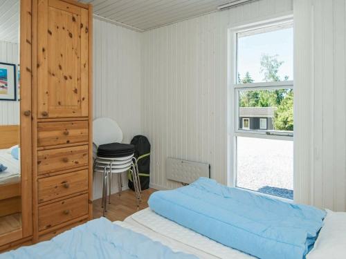 a bedroom with a bed and a dresser and a window at Holiday home Knebel XI in Knebel