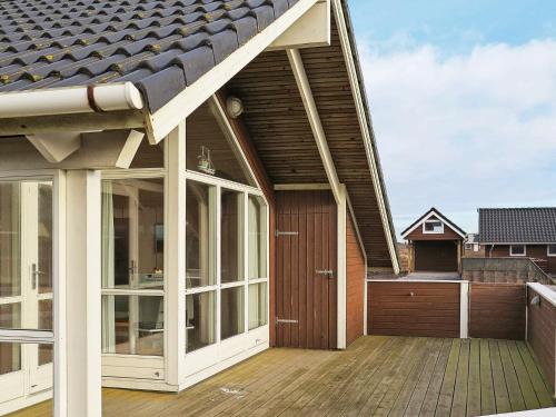 a house with a wooden deck with a roof at 6 person holiday home in Harbo re in Harboør