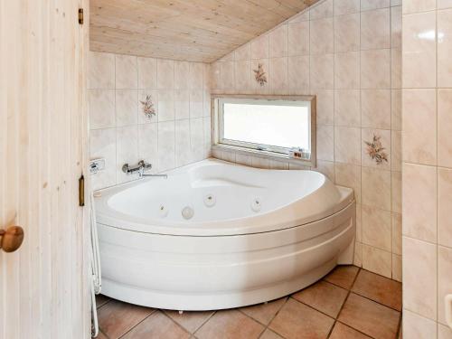 ヘンネ・ストランドにある6 person holiday home in Henneの窓付きのバスルーム(大きな白いバスタブ付)