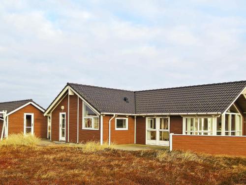 a house on a hill next to a field at 6 person holiday home in Harbo re in Harboør
