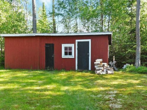 a red shed in the middle of a yard at 5 person holiday home in L GDE in Himmersundet