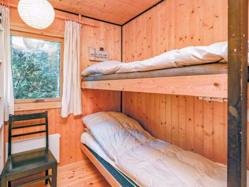 ブロックフスにあるThree-Bedroom Holiday home in Blokhus 21のキャビン内の二段ベッド2台が備わる客室です。