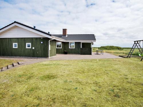 a green and white house with a large yard at 8 person holiday home in R m in Bolilmark