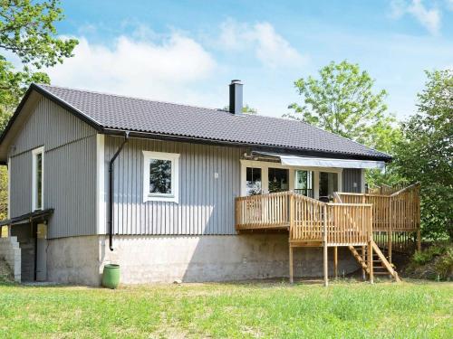 a small house with a porch and wooden decks at 5 person holiday home in RYSSBY in Ryssby