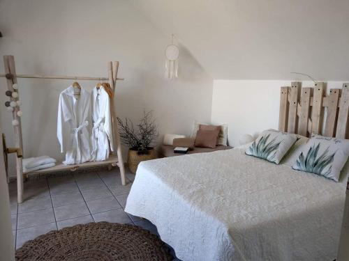 ein Schlafzimmer mit einem Bett und einige angezeigte Kleidung in der Unterkunft La Plaine-itude & Spa in Saint-Paul