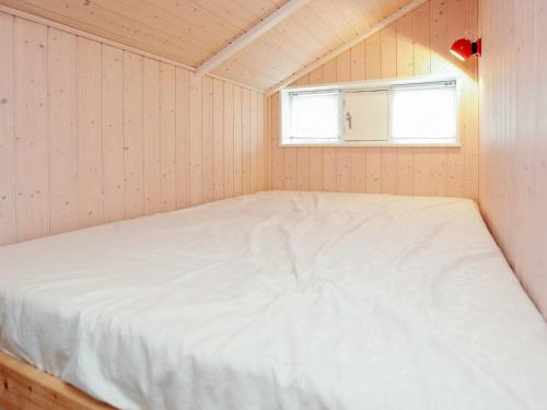 Ce lit se trouve dans une petite chambre dotée d'une fenêtre. dans l'établissement 8 person holiday home in H rve, à Hørve